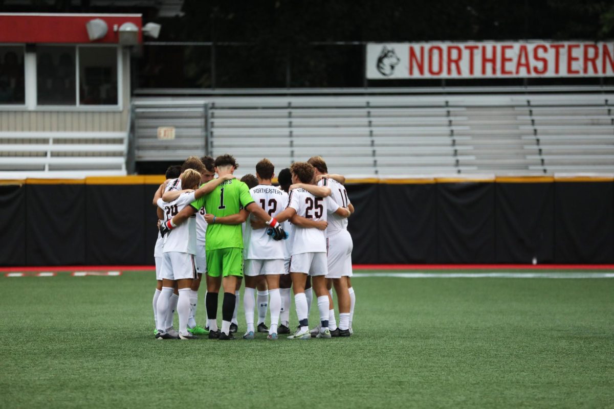 Members+of+the+men%E2%80%99s+soccer+team+huddle+before+a+preseason+intra-squad+scrimmage.+The+Huskies+welcomed+nine+new+players+this+season.