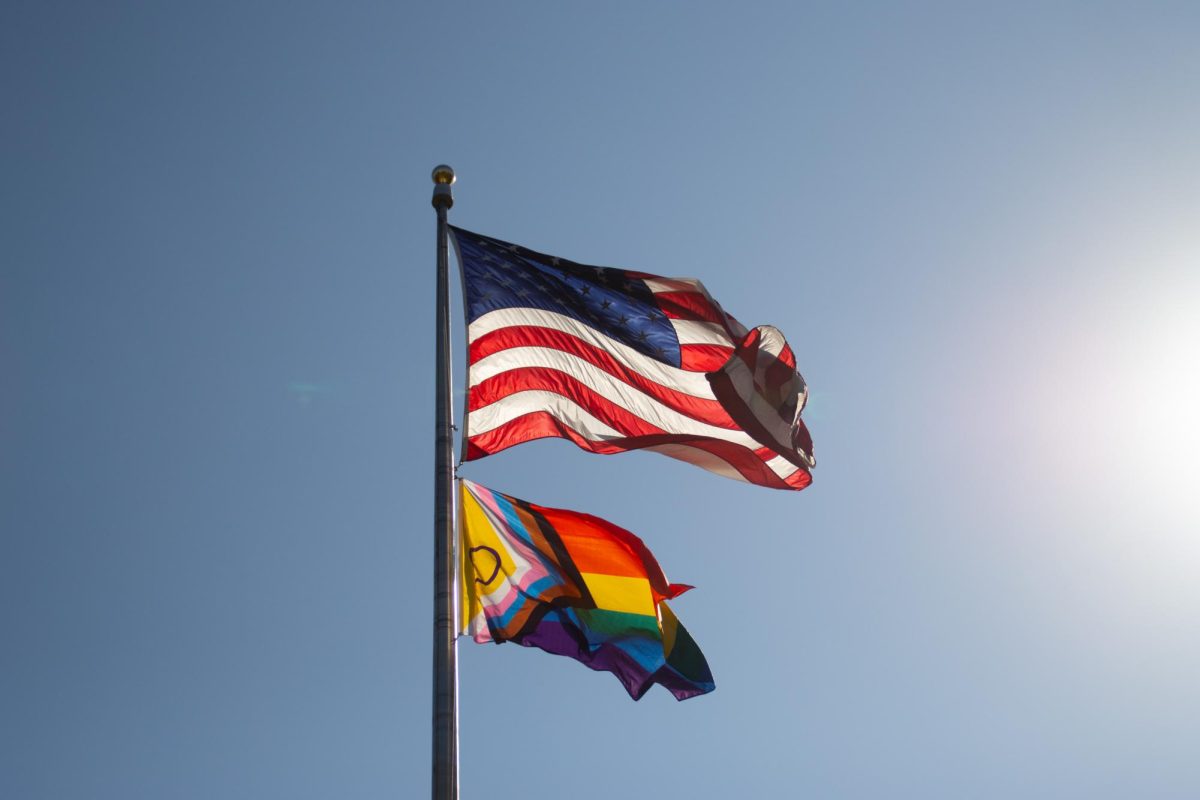 The Pride flag waves below the United States flag from the flag pole on Centennial Common. The Pride flag was raised during a flag-raising ceremony hosted by the NU LGBTQA Resource Center Oct. 4.