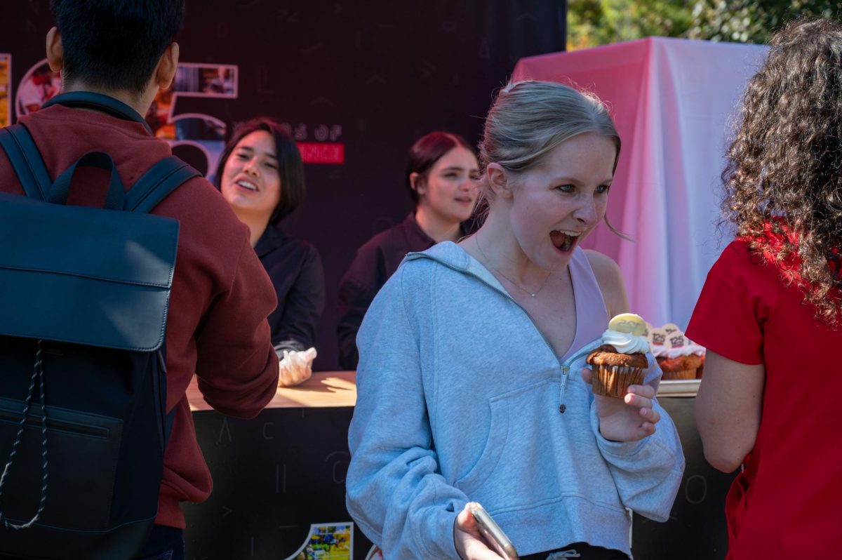 A student excitedly carries a commemorative 125th anniversary cupcake. Cupcakes were just one of several opportunities for free anniversary items.