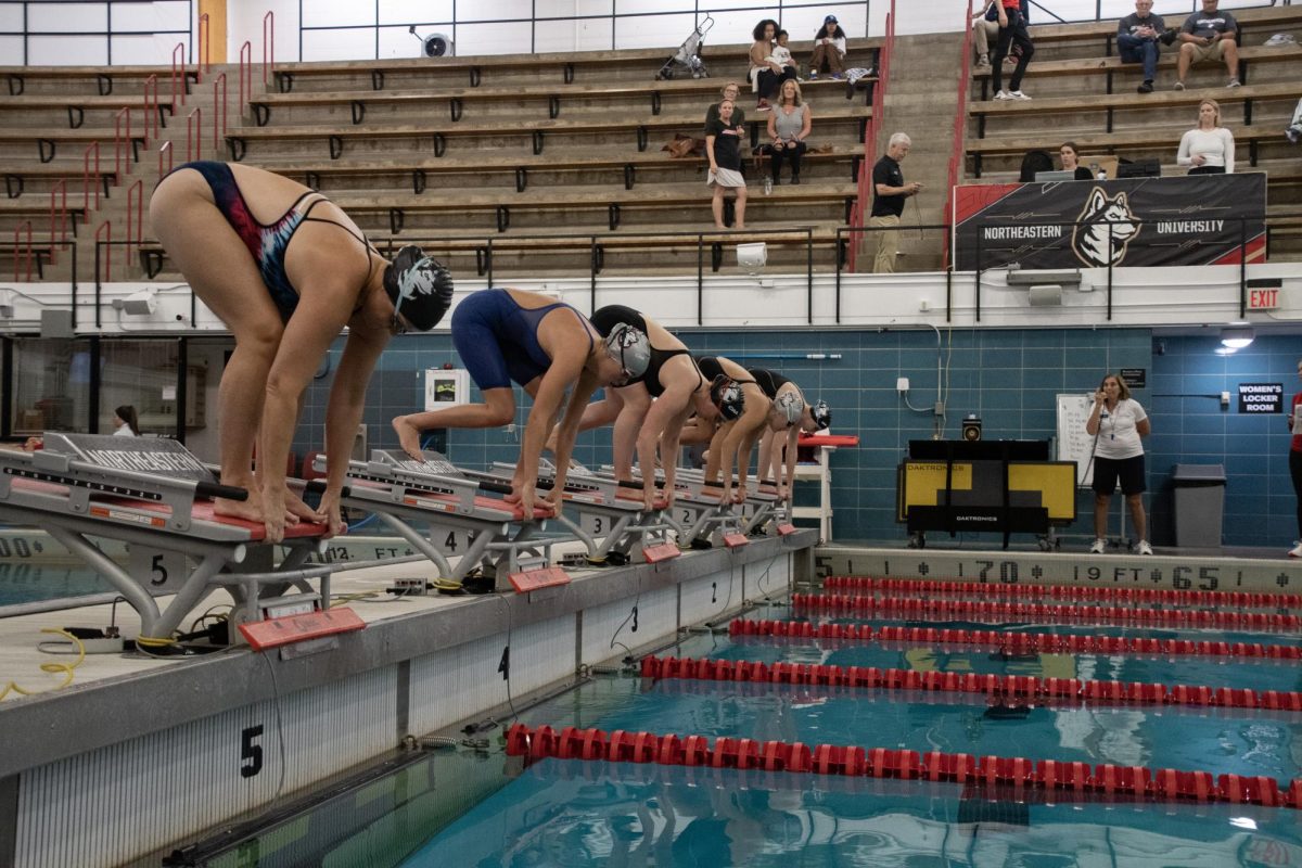 Dickinson (left) prepares to compete in the 100-yard freestyle alongside members of the current team. Dickinson was one of three competing alumni at the meet. 