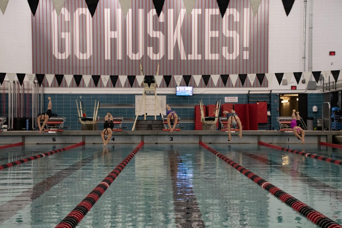 (Left to right) Coco Fraser, a senior breaststroke/IM swimmer, Bendall, Linell, Marcela Scaramuzza, a sophomore breaststroke/butterfly swimmer and Joyce Wu, a freshman breaststroke swimmer, dive into the water for the 50-yard breaststroke. The meet offered a chance for newer team members to showcase their abilities alongside older members.