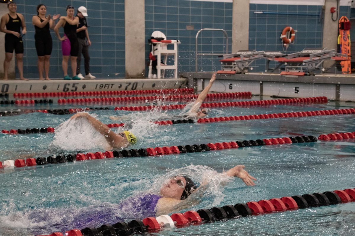  Junior Nicole Linell, sophomore Elisabeth Bendall and alumnus David Govoni (1993-1996) compete in the 100-yard IM finals. On Sept. 23, Bendall and Linell both competed in breaststroke for the women’s swimming and diving team