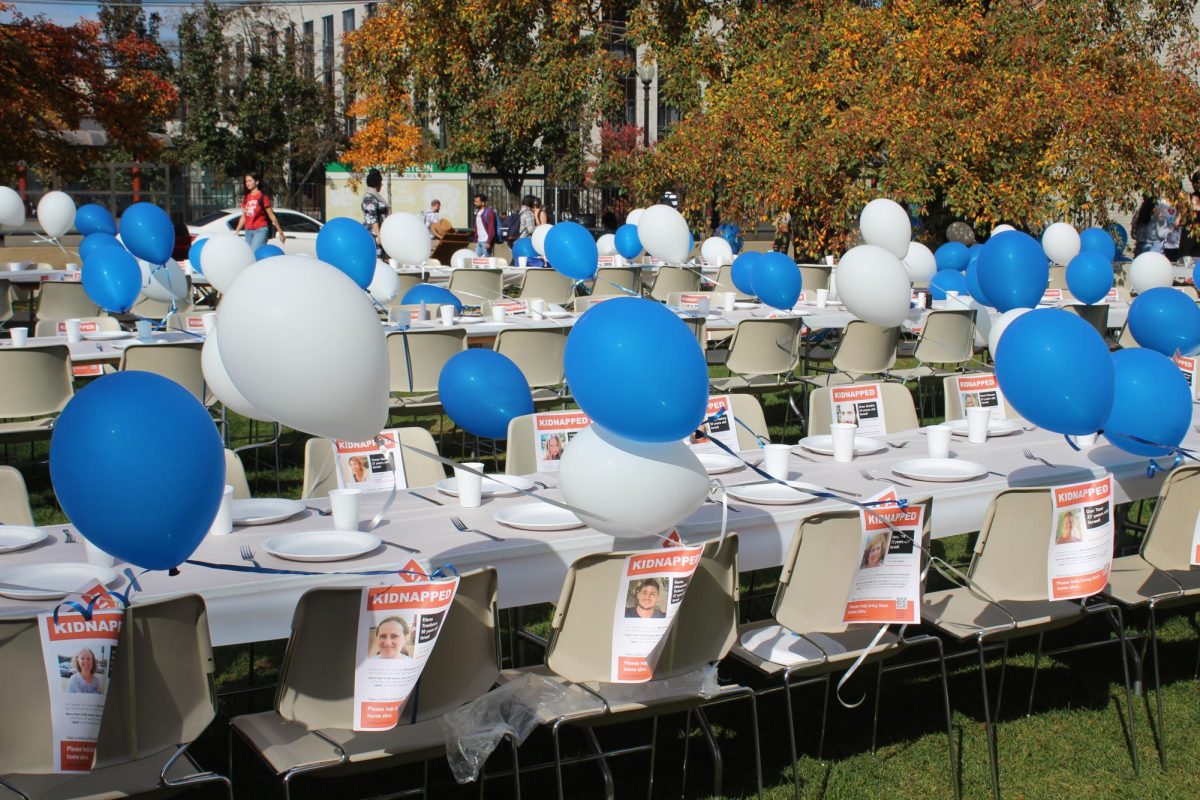 An empty Shabbat table sits in Cabot Quad honoring the 229 hostages taken by Hamas. Posters with names and faces of hostages were attached to chairs.





