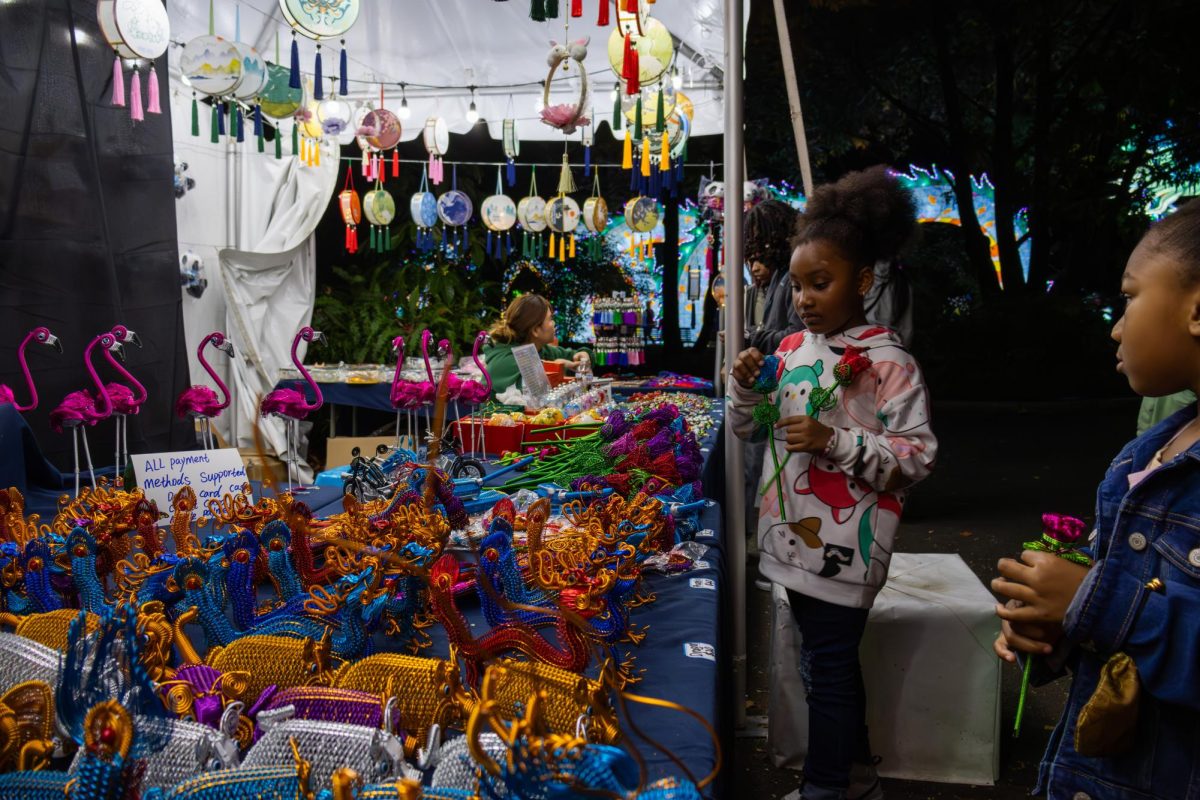 A family explores a booth selling Chinese wire animals and lanterns, deciding to buy roses as a souvenir. The booth was located before the Chinese wonderland area and promoted Chinese culture and arts.