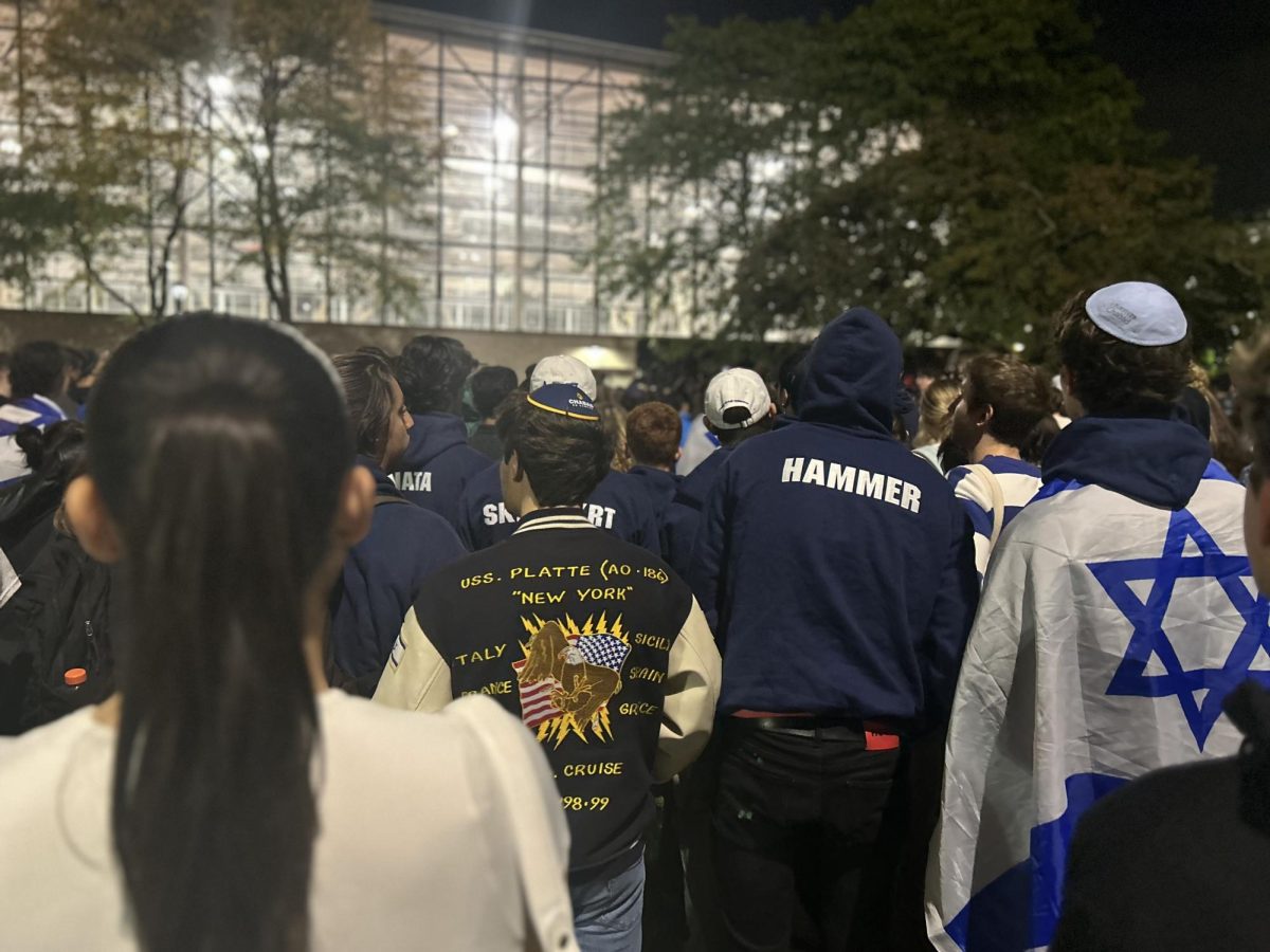 Community+members+fall+silent+as+Hillel+president+Julia+Gilinsky+begins+to+address+the+group.+Many+students+wore+kippahs+or+the+flag+of+Israel+to+show+support.