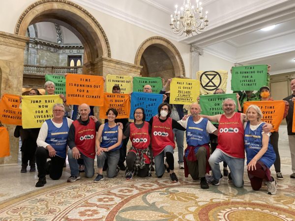 Protestors from Extinction Rebellion pose for a group photo in the Massachusetts State House. Activists hoped that their protest would help stop Governor Maura Healy from committing to building new fossil fuel infrastructure in the state.