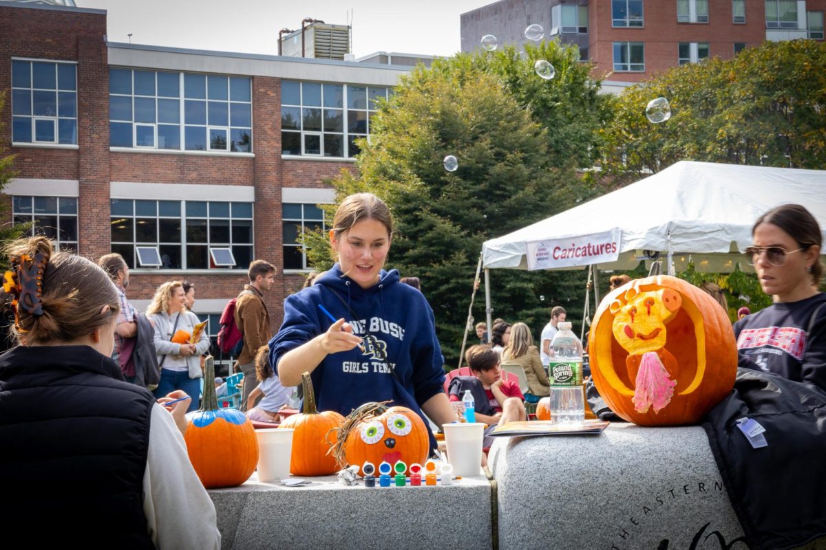An attendee paints a pumpkin. Participants were able to take a pumpkin and choose between painting or carving it.