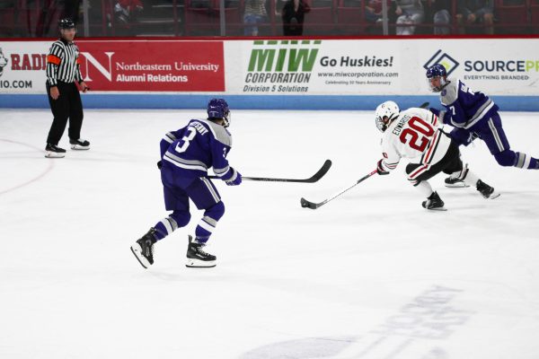 Graduate student foward Brett Edwards pushes the puck through
Stonehill defenders and up the ice. Edwards joined the Northeastern
squad after four seasons at the the University of Denver.