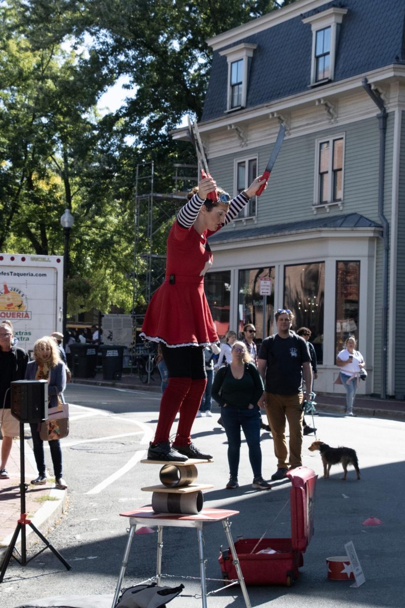 Cate Great,a street performer, balances on a set of boards and pipes as she prepares to juggle knives. She was trained at the Quebec Circus School.
