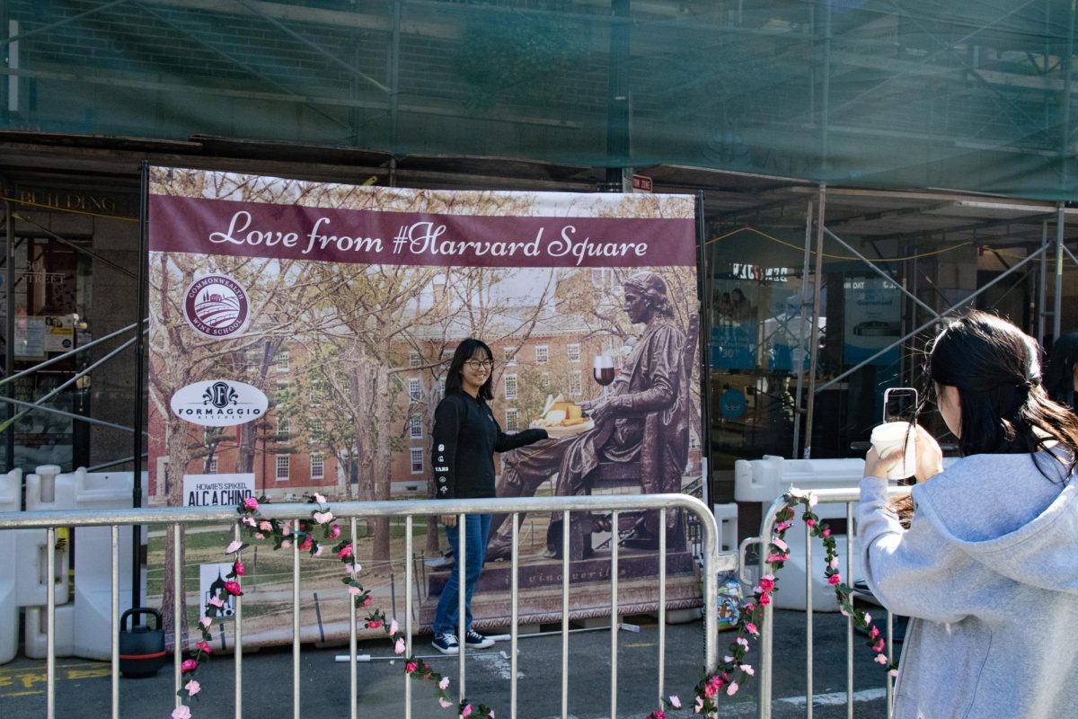 A woman poses for a photo in front of a banner reading “Love from #Harvard Square.” Harvard Square’s Oktoberfest takes place annually on the Sunday of Indigenous People’s Day weekend.