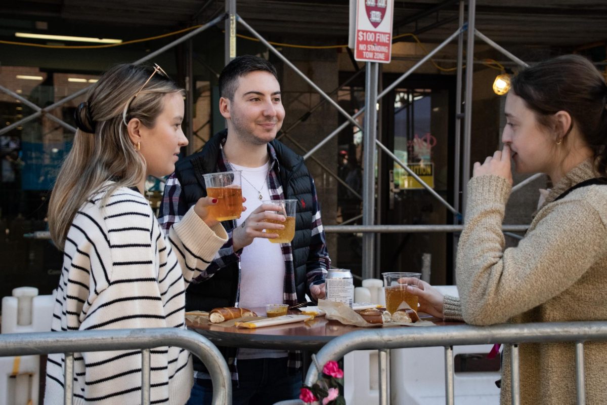 Three people enjoy German beer and pretzels in the spirit of Oktoberfest. Oktoberfest was originally established as a public festival in the early 1800s in Germany. 