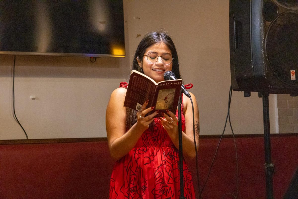 A participant at Trident’s Poetry Open Mic Night reads one of her favorite works from a book of poetry by Margaret Atwood. She chose to read a piece that inspired her that week.