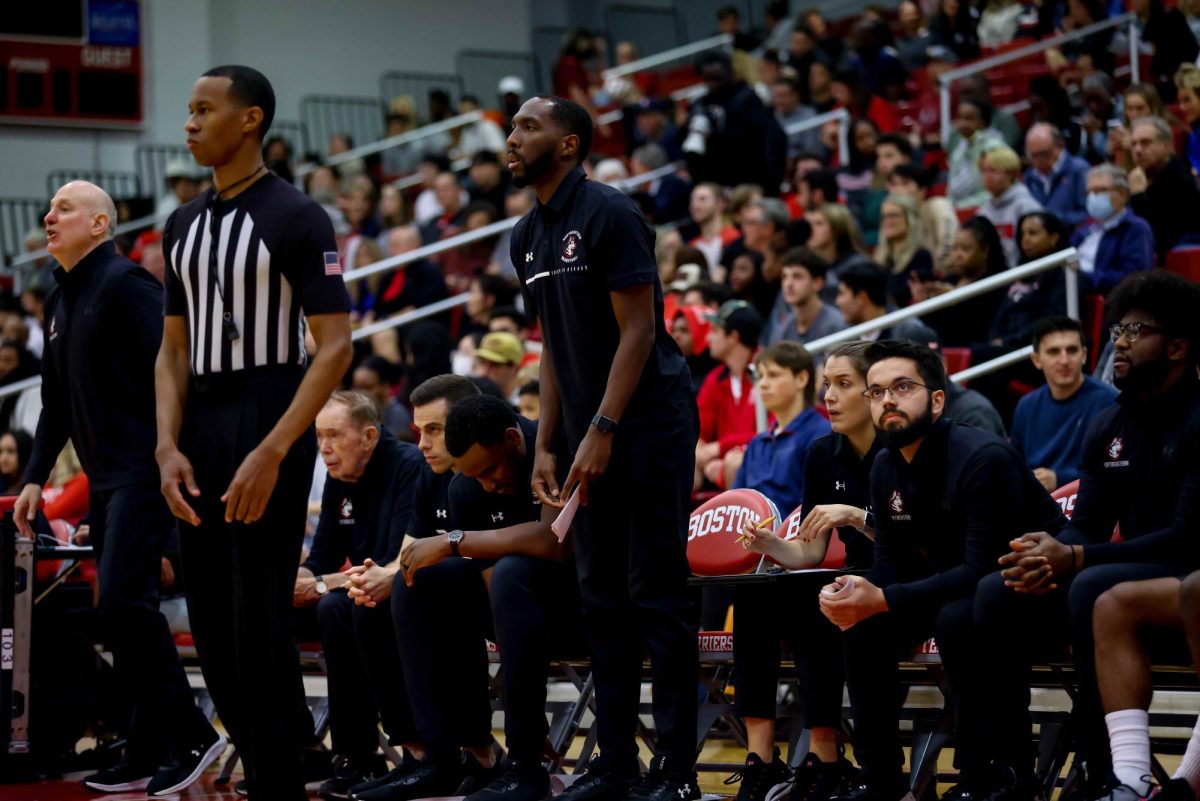 Men’s basketball assistant coach Joel Smith watches the Huskies from the sidelines. After four standout years as a Husky from 2009-2013, Smith played professionally and eventually returned to Northeastern as a coach in 2021. Photo courtesy Jim Pierce/Northeastern Athletics.