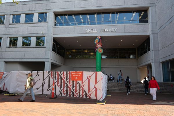 A barrier blocks off the main entrance to Snell Library while the library undergoes renovations.  The library announced that students will not be expected to remain quiet in the library during these renovations.