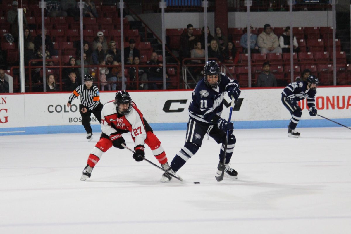Junior+forward+Justin+Hryckowian+reaches+for+the+puck.+The+captain+scored+the+Huskies+second+goal+in+their+Nov.+17+contest+against+UNH.+