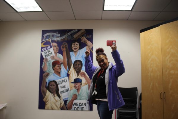 Tomasa Rodríguez, a janitor at Northeastern since 2000, poses in front of the painting depicting union members with the words of the American Dream. You can see here that were asking for justice just like were asking for now,   Rodríguez said of the painting.