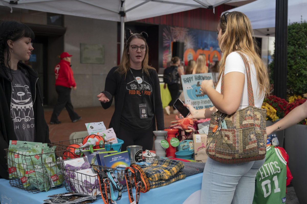 Katrina Chapman, a vendor for The Fish & Bone, a pet store on Newbury Street, speaks with a potential customer. Many vendors used the parade as an opportunity to meet pet parents. “We love going to events around town,” Chapman said. “Meet people, see dogs; that’s our favorite part.”

