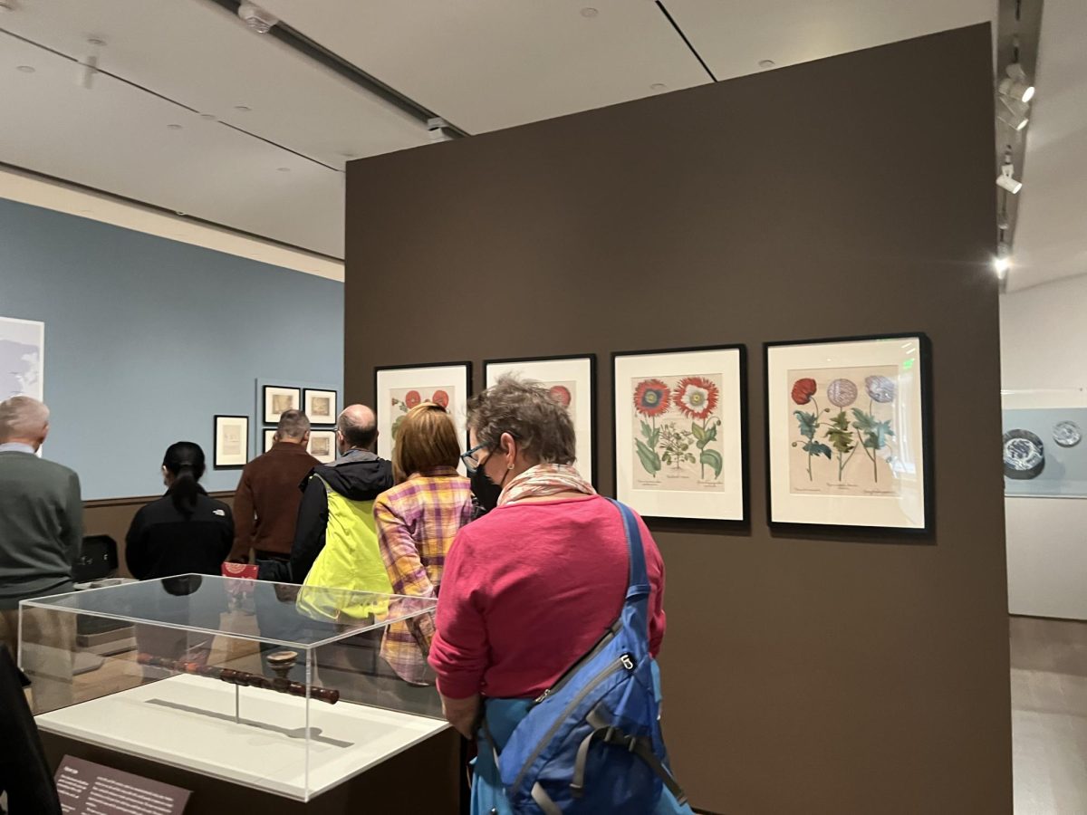 Attendees of the gallery talk walk amongst the Objects of Addiction exhibit Oct. 18. The exhibition was created to explore the entwined histories of the opium trade and the Chinese art market in the late 18th and early 20th century.