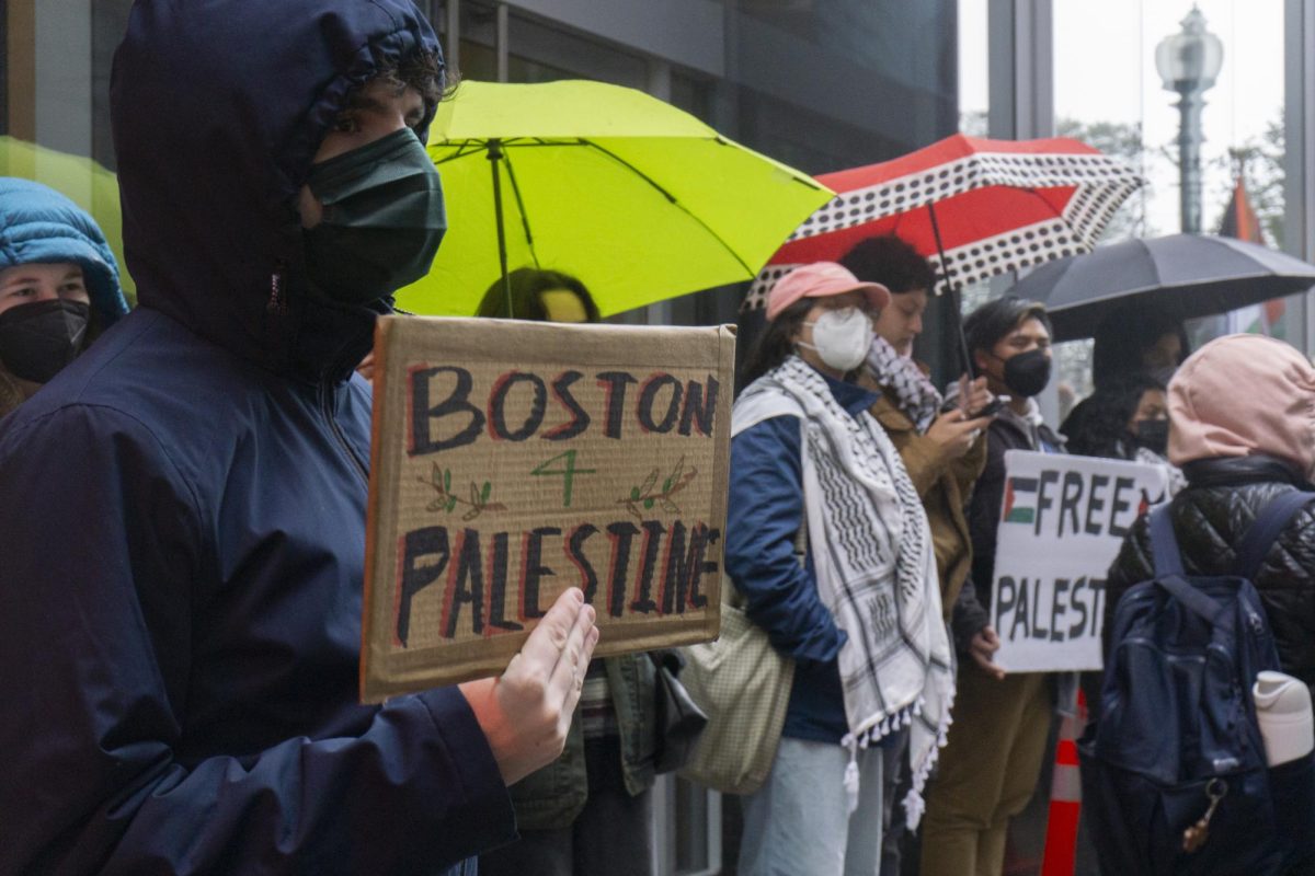A protester holds a sign in support of Palestine. People began gathering outside the Ritz-Carlton around noon.