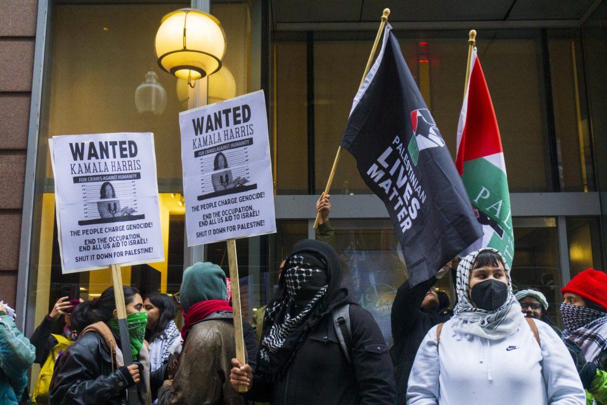 Protesters hold picket signs calling out Harris in the form of a fictitious wanted poster. Others showed solidarity with Palestine by waving flags.