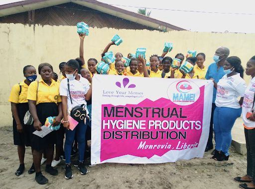 Students in Monrovia, Liberia hold up period products. Love Your Menses collaborated with Mavee Maternal Empowerment Initiative to provide communities with menstrual products. Photo courtesy Ebere Azumah. 