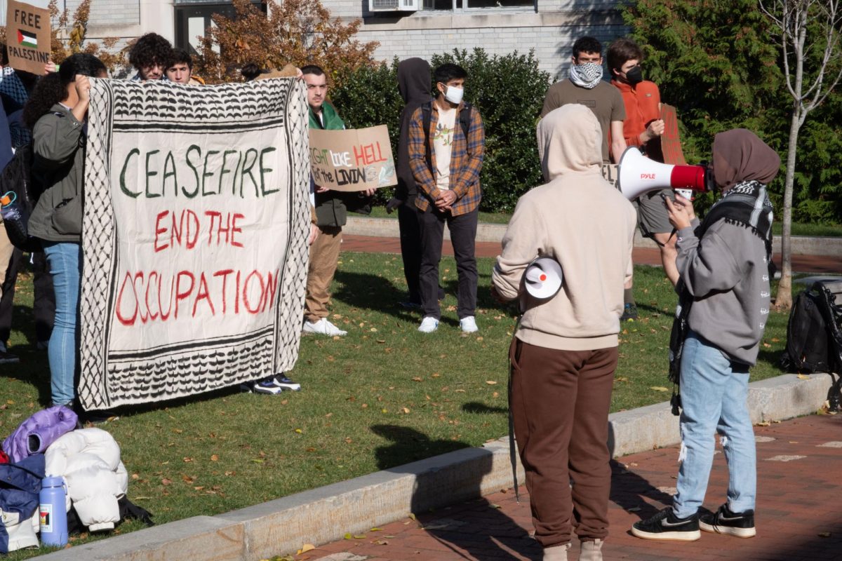 Attendees listen to a speaker read a speech at the rally. Protestors demanded the university and law professionals call out genocide against Palestinians and divest from military companies.