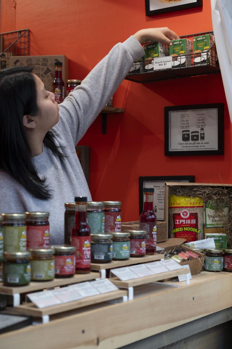 Li reorganizes the display for the Mama Lam’s booth. A majority of small businesses at the market were woman-owned.