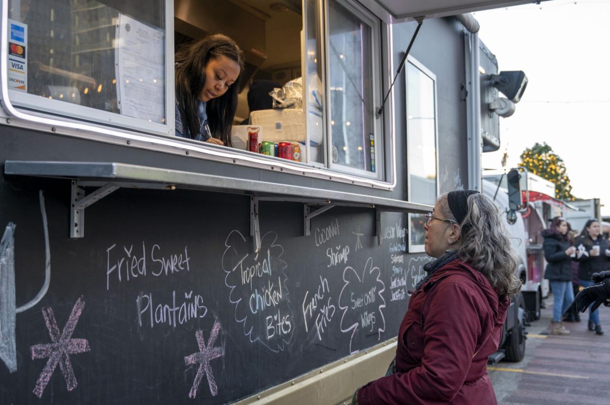 A food truck vendor for  ZaZ Restaurant writes down a customer’s order. The Caribbean fusion restaurant served up specialties such as salmon hush puppies and jerk chicken.