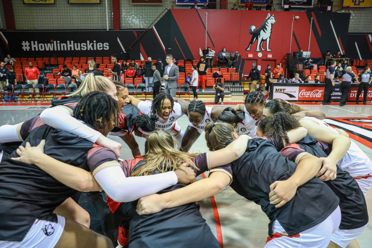 The Huskies huddle before tip off. This season, Northeastern is off to a 2-1 start. Photo courtesy Jim Pierce/Northeastern Athletics.