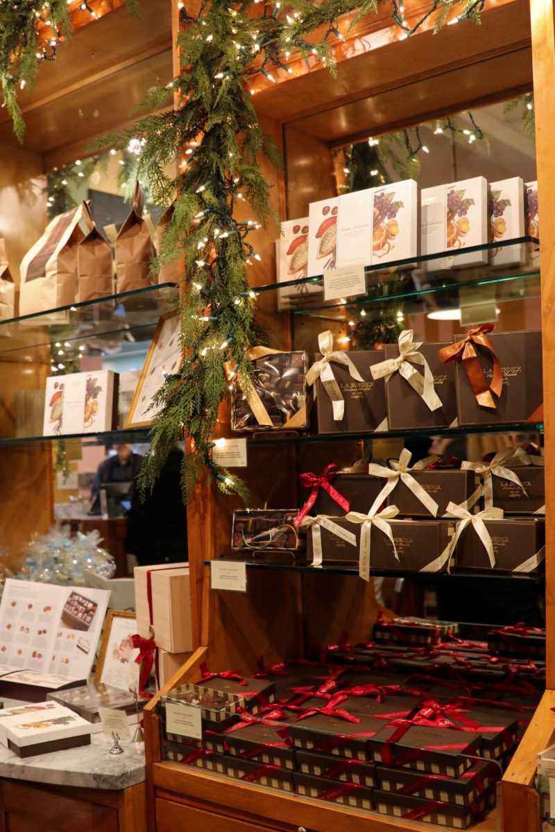 Gift boxes of chocolate sit on a shelf.