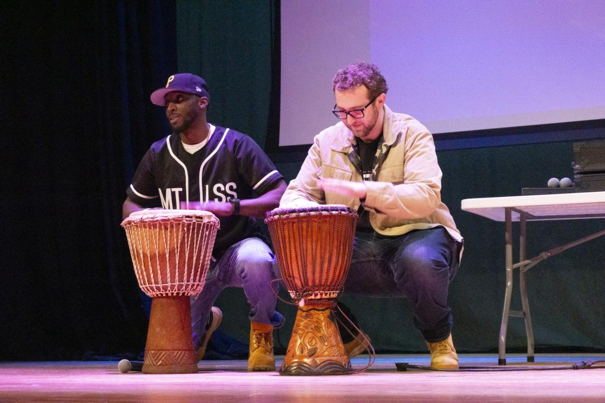 Mr. PSA (left) and Sam Buck (right), a stand-up comedian, entertain the audience between acts while playing the drums. Mr. PSA engaged the crowd throughout the night with comedy and music.