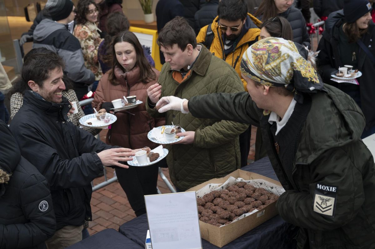 A  Blackbird Doughnuts employee hands out samples of triple chocolate donut holes. Many visitors were too excited to wait and began trying their treats while they went down the row of businesses.