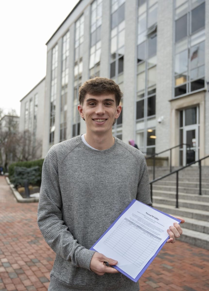 Tyler Brogan poses with a copy of his petition. Brogan began petitioning for a sustainability class to be added to NUpath since last year.