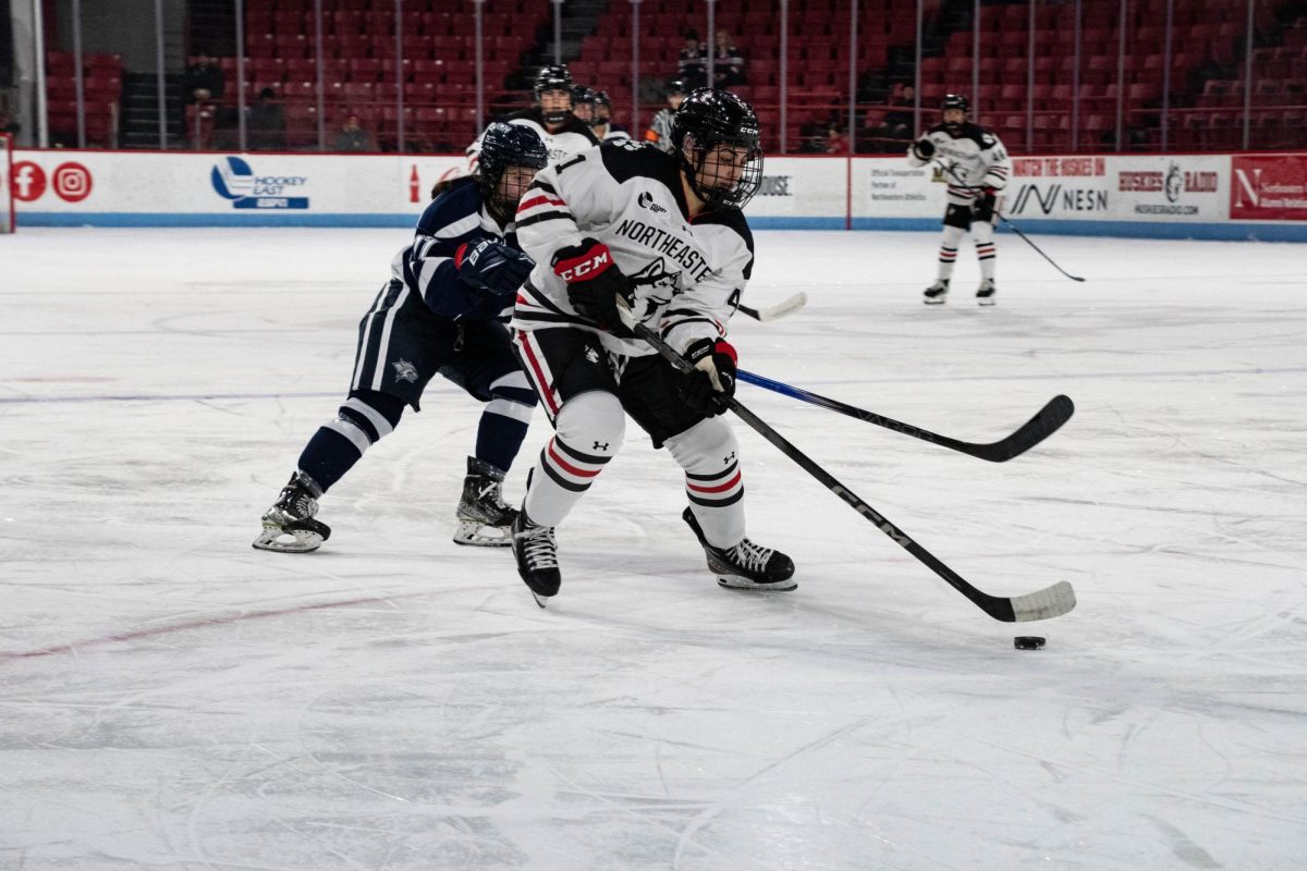 Jules Constantinople protects the puck from a pursuing UNH player. Northeastern beat the Wildcats 2-1 in Fridays game. 