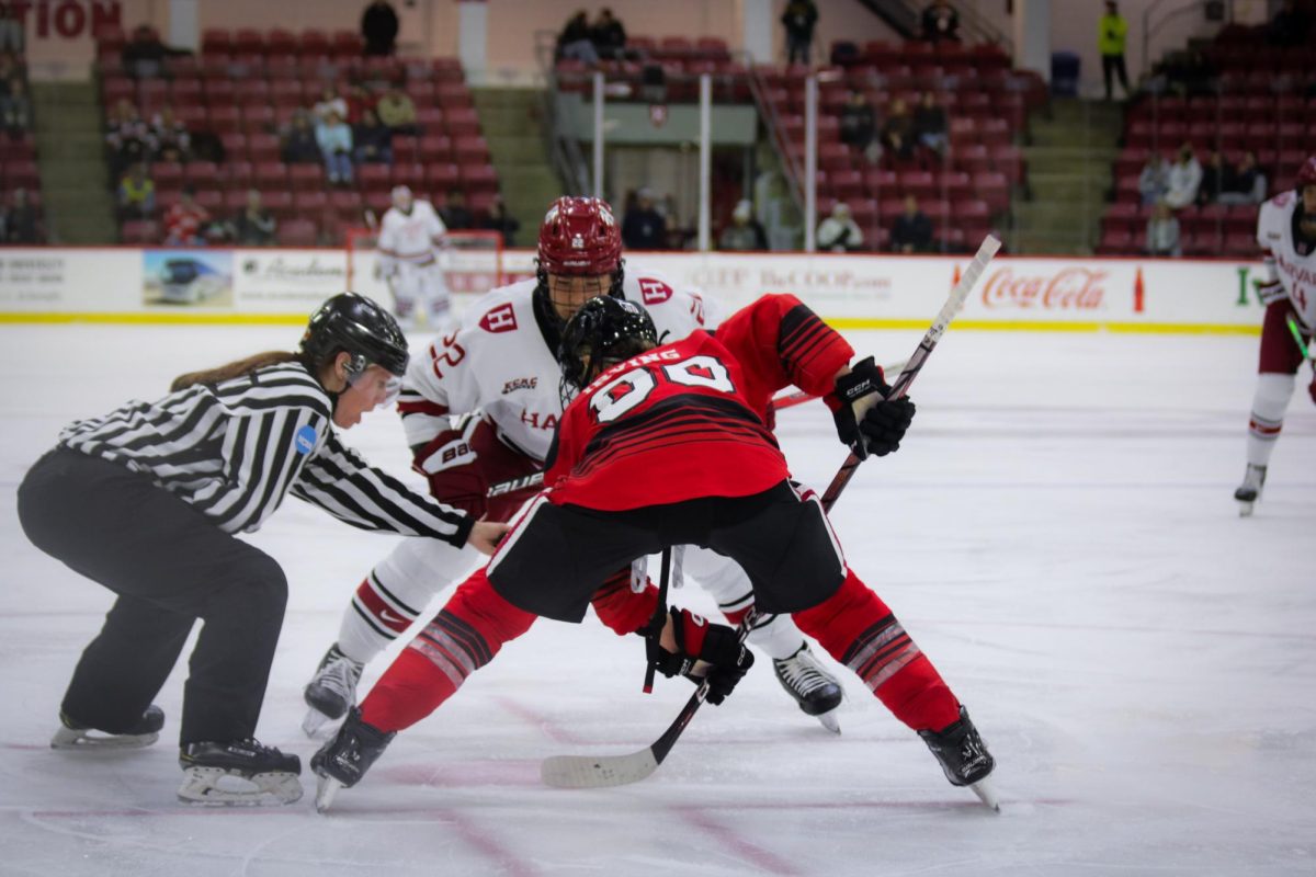 Northeasterns Skylar Irving takes the faceoff against Harvard captain Shannon Hollands. Irving notched a team-high nine shots on goal in Tuesdays Womens Beanpot semifinals. 