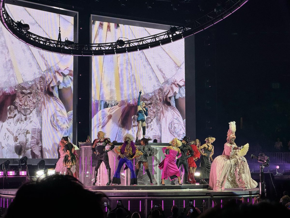 Madonna raises her hands as dancers circle around her. The Celebration Tour showcased various milestones across her decades-long career.