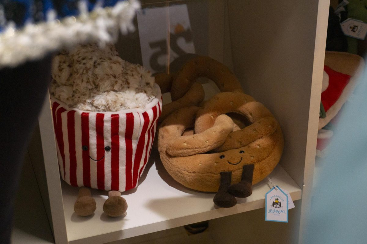 A popcorn bucket and pretzel Jellycat wait for their new homes on a lower shelf. Many people neglected plushies that were not at eye level.