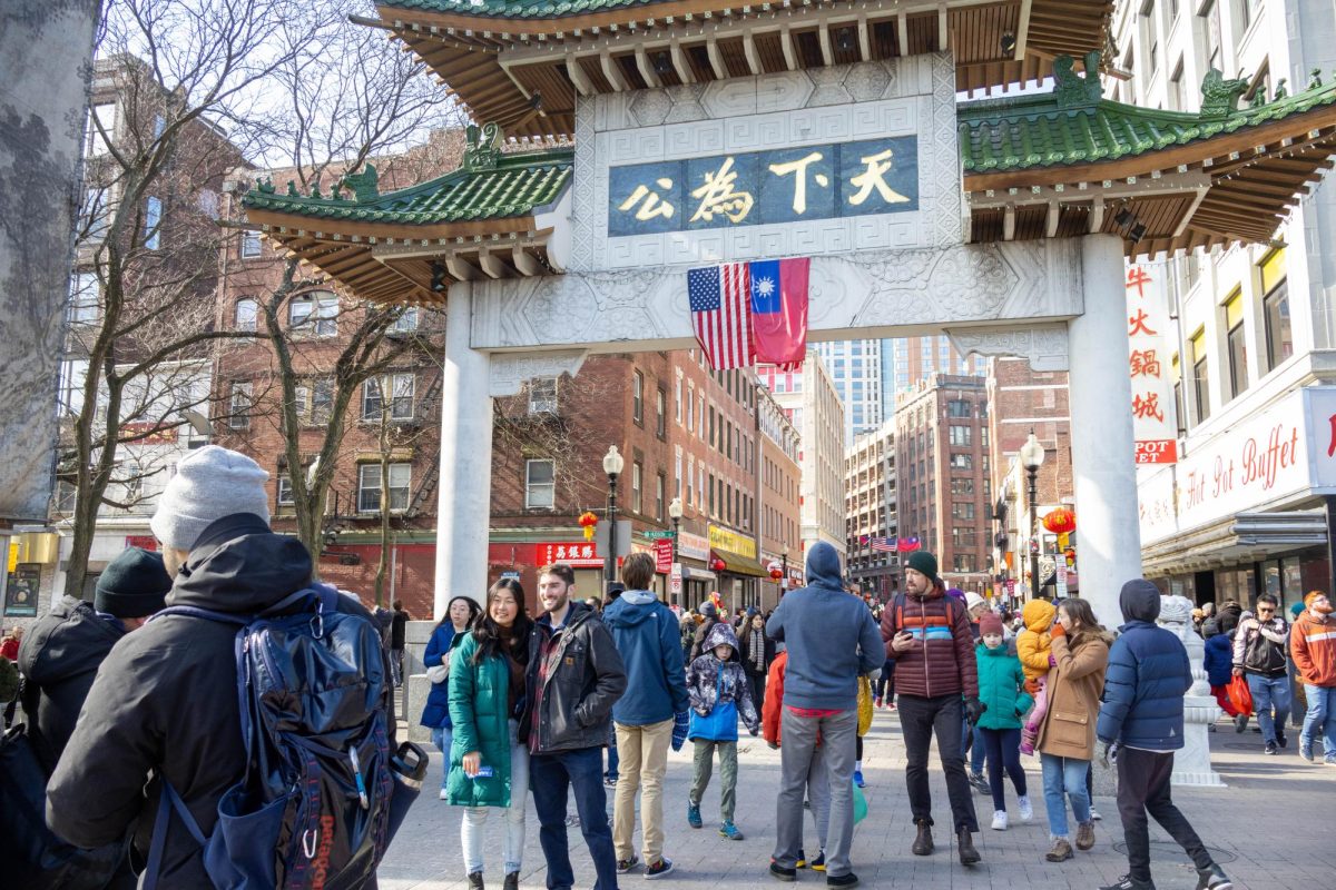 Families, friends and couples mingle around the China Trade Gate, posing for photos and passing through the event area. The gate was erected in Boston in 1982 as a gift from Taiwan.