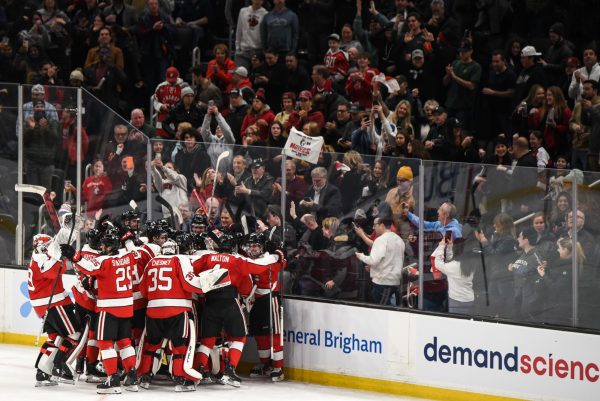 The Huskies celebrate their Beanpot semifinals victory. Northeastern defeated Harvard 3-2 in overtime .