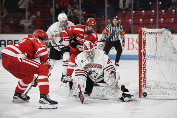 Cameron Whitehead blocks away a shot from Boston University. The Huskies defeated the Terriers 4-3 in overtime Jan. 30.