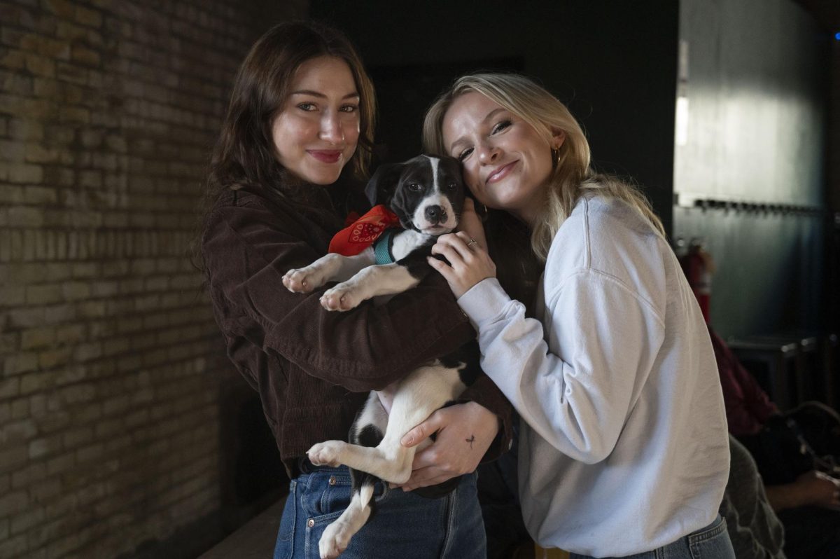 Nicola Kachikis (left), a third-year student at Boston University studying public relations and psychology, and Jenna Dean, a fourth-year student at Boston University double majoring in acting and political science, pose for a photo with a puppy. The event reinforced the friends’ desires to adopt a puppy following graduation. “I don’t really like going out, but I would go to this any day,” Dean said.