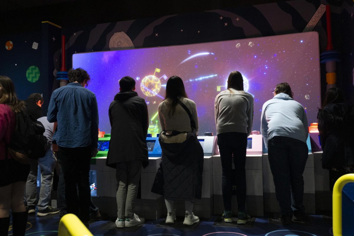 Attendees play at the Spaceship Build and Scan attraction. People built Lego spaceships to be scanned into the system and then flown in the game.