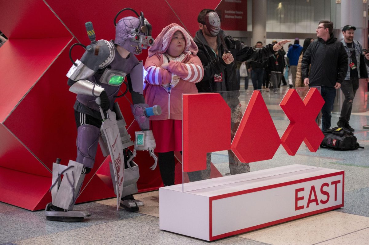Three cosplayers pose for a photo with a PAX East sign. The convention ran from March 21 to March 24.