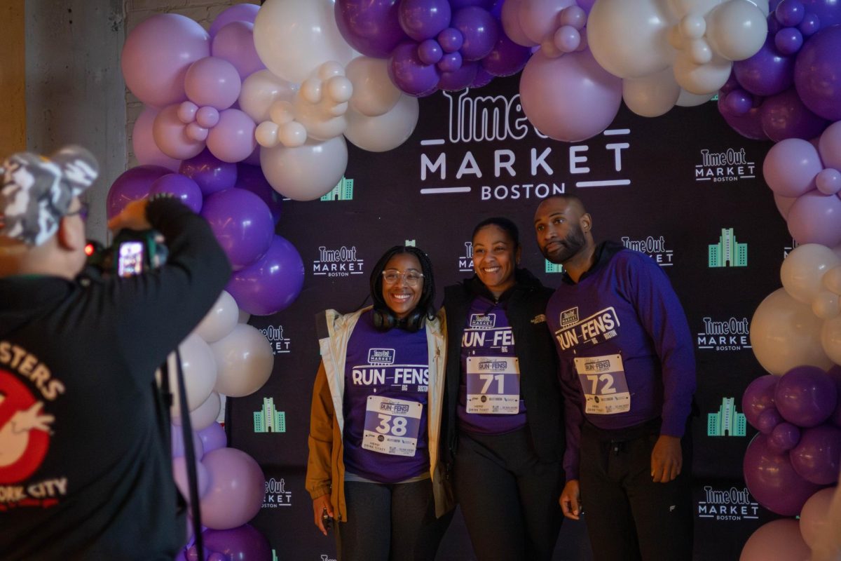 Participants pose for an event photographer under a purple and white balloon arch in Time Out Market. Many participants happily posed for photo opportunities when they were notified that the images would be distributed at a later time.