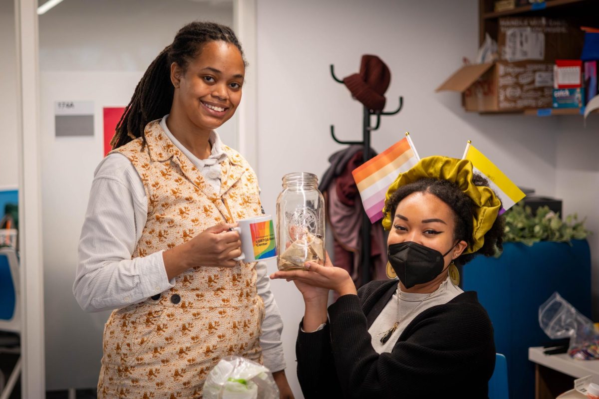 Wright (left) and Julissa Emile, an herbalist, pose for a photo in the LBGTQA Resource Center. After Wright discussed the importance of balancing capitalism with self-care during their communal care workshop, Emile handed out rose and ginger tea from their garden.