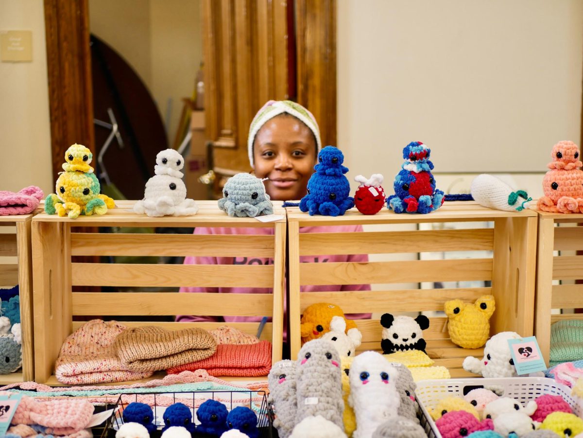 Carolina Viktor, the owner of Cles Cuddly Creations, sits behind a row of crocheted animals on display. Nearly all goods vendors sold were handmade. 