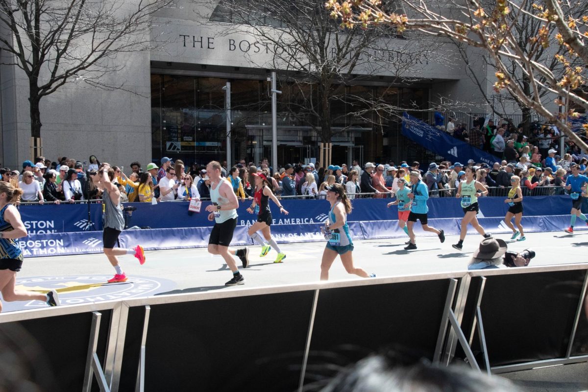 A crowd watches as runners enter the final stretch of the Boston Marathon in front of the Boston Public Library. Fifteen participants in the marathon ran to raise money for the Boston Public Library.
