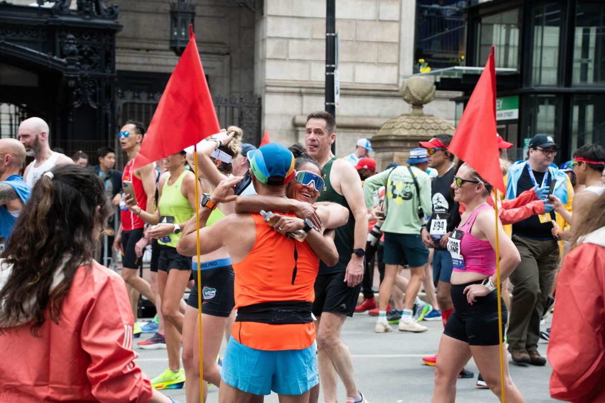 Two runners embrace each other by Copley Square. Streets such as Beacon Street and Boylston Street were blocked off for the marathon.
