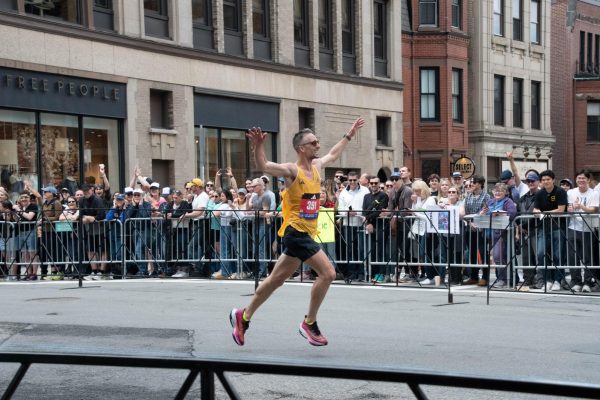 Sean O’Reilly smiles and outstretches his arms while running the marathon. O’Reilly had a finish time of 2:28:21.