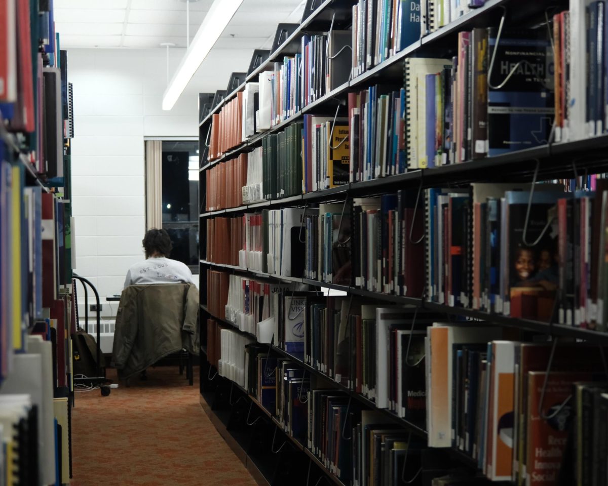 A student silently works among the bookshelves of the Law Library. The school’s database made some library contents available digitally.